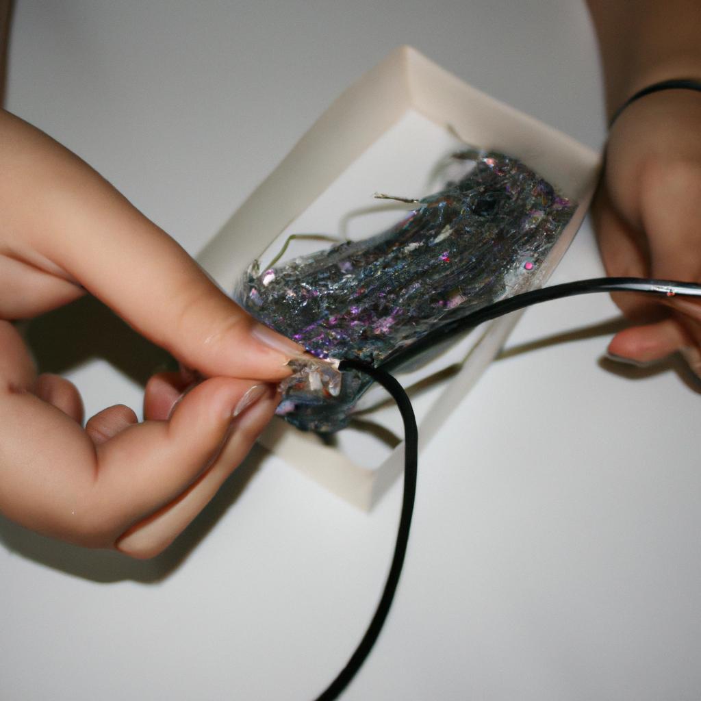 Person wrapping wire for jewelry